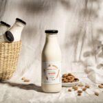 Mount Sinai almond milk bottle with a basket of bottles and almonds on a textured cloth.